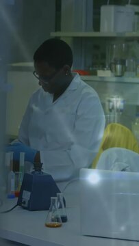 Vertical video: Glowing overlay shifting, lab tech pipetting and vortexing samples for testing