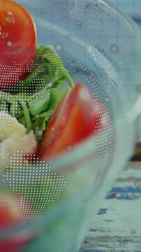 Vertical video: Camera pulling close glass bowl, tomato wedge and greens, overlay showing food ad