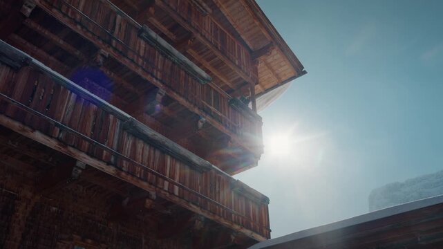 Sunlit wooden chalet against clear sky in Zillertal. Perfect for travel or winter promotional content.