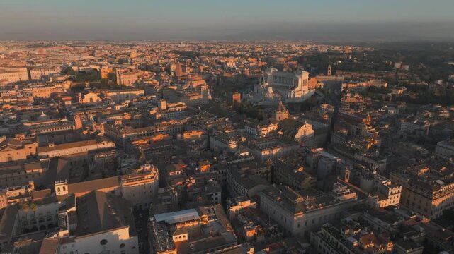 Rome Sunset aerial drone of city center during golden hour featuring the Victor Emmanuel II National Monument and historic Italian architecture.