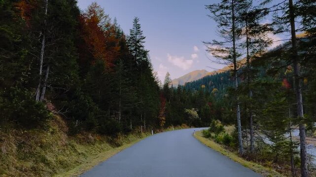 Autumn mountain road along Rissach river through Karwendel forest, Engtal valley, Tyrol, Austria, POV
