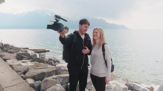 Couple vlogging at lakeside of Lake Geneva during the day in Montreux, Canton of Vaud, Switzerland, gimbal shot