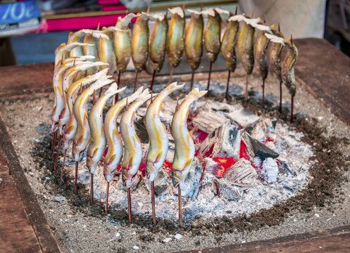 Grilled fish over fire at a food stall, Hanami Fest, Ueno Park, Tokyo, Japan