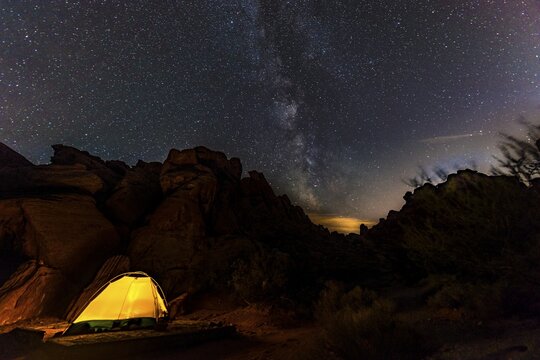 Tent on a campsite with starry sky above and Milky Way, night scene, Valley of Fire, Nevada, USA