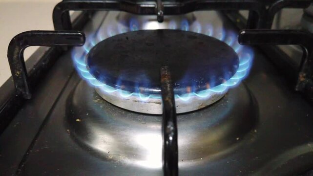 Close-up of a gas flame on a cooking stove in a kitchen, showing the burner turned on and ready for cooking. Ideal for culinary content, food preparation videos, cooking tutorials, and kitchen backgro