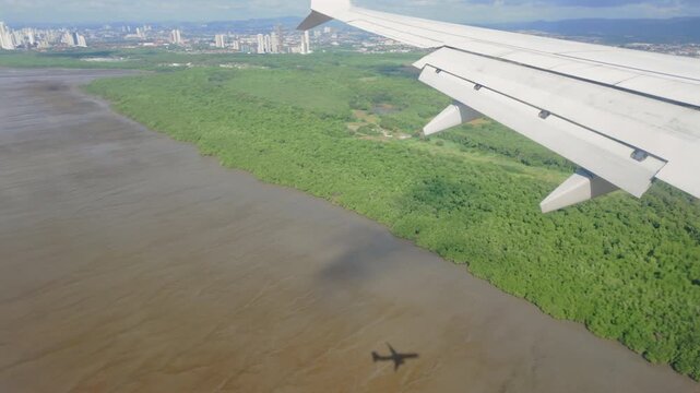 Skyscrapers and Marshes visible outside plane window during descent into Tocumen International Airport, Panama City, Panama, POV