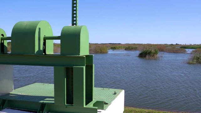 Water gate mechanism managing flow in wetland system on sunny day