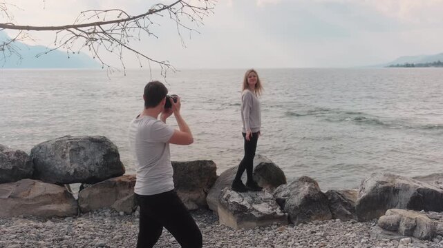 Male photographer directing a female model with lake behind during the day, gimbal shot