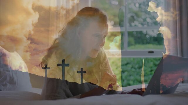 Woman on bed looking at laptop, typing and gesturing while faint 3-cross overlay shifting for faith
