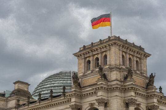 Reichstag with waving German flag at the Spree, government quarter, Berlin, Germany