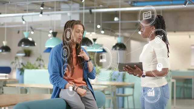 Man sitting on bench in office speaking shifting HUD highlighting icons while woman holding tablet