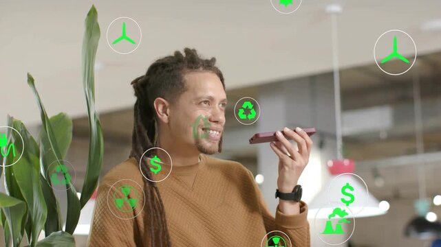 Man speaking into phone, pitching green finance while smiling, icons floating around face and torso