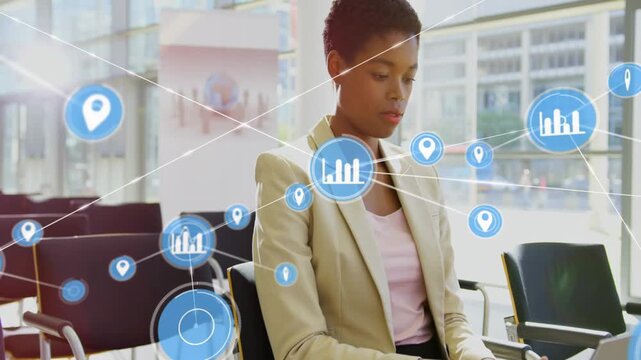 Business woman typing on laptop, initiating blue icons forming network and sweeping across lobby