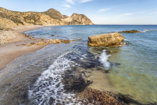 Rocks in the water, waves crashing against rocks, sandy beach with rocky cliffs, Paralia Paradisos, Kos, Dodecanese, Greece