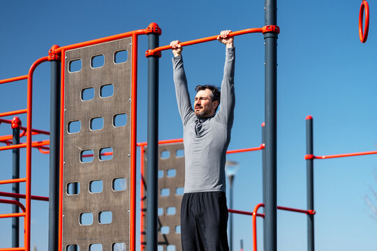 Man doing pull up exercise at outdoor gym