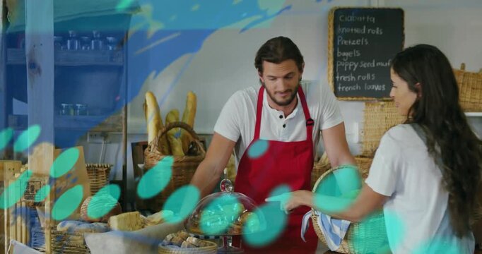 Woman approaching bakery counter man baker lifting dome teal numbers helping her choose rolls