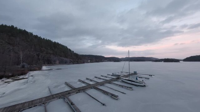 Frozen marina with sailboat at sunset in Telemark Norway