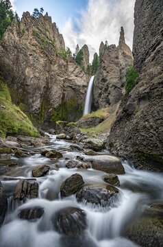 Waterfall flowing through eroded landscape with rock outcrops, Tower Fall with Tower Creek, Yellowstone National Park, Wyoming, USA
