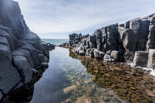 Water gathering between rocks, Roman Bath, Hexagonal basalt column by the Sea, Blackhead, Dunedin, Otago, South Island, New Zealand