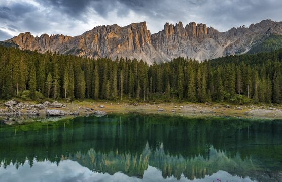 Sunset, dramatic clouds, Latemar group reflected in the Karersee, Diamantidturm, mountain peaks, Eastern Latemarspitze, Col Coron, Lago di Carezza, Welschnofen, Bolzano, South Tyrol, Italy