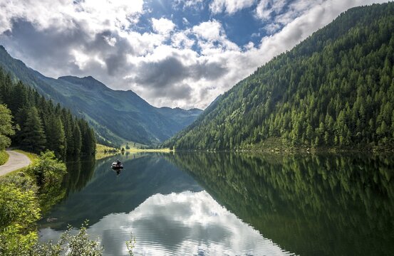 Angler in a boat, reflection in the lake, Riesachsee, Rohrmoos-Untertal, Schladminger Tauern, Schladming, Styria, Austria