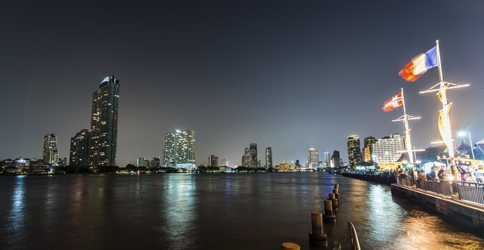 River promenade in the evening with a Ferris wheel and the skyline on the river Mae Nam Chao Phraya, Asiatique, Bangkok, Thailand