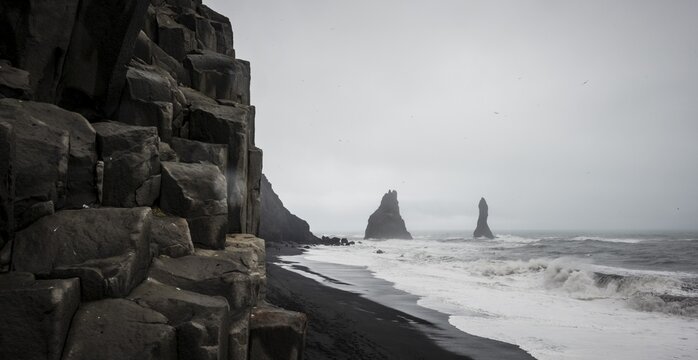 Basalt columns and cliffs, black sand beach, bad weather, Reynisfjara beach, South Iceland, Iceland