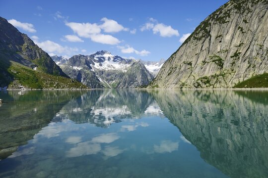 Mountains around the Grimsel Pass are reflected in Gelmerstausee reservoir, Guttannen, Canton of Bern, Switzerland