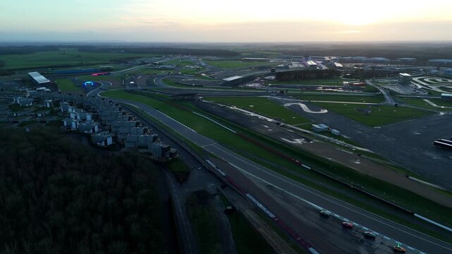 Aerial perspective of the legendary Silverstone F1 venue and modern spectator grandstands in the UK under a winter golden hour sky.