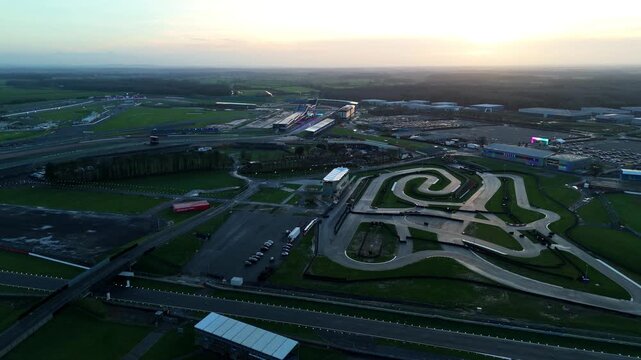 Aerial view of Silverstone Circuit at sunset in winter showing grandstands and the high speed Formula 1 Motorsports venue in Northamptonshire UK.