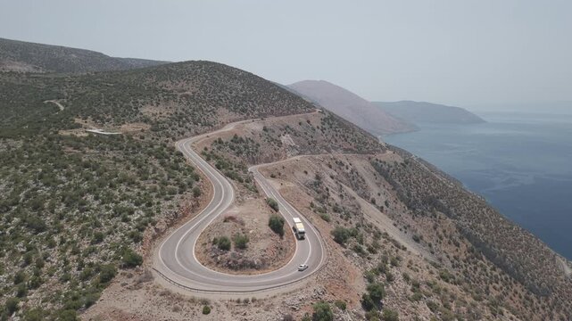Static shot of truck and car driving through curved road in Lesbos, Greece, sunny day scenic road 4K.
Static shot of a truck and car driving through a curved scenic road in Lesbos, Greece on a sunny.