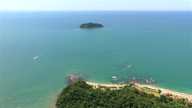 Right tracking aerial over jungle hill looking towards Praia da Bacia da Vov&oacute; and Praia da Saudade, with islands in the ocean.
