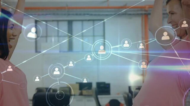 Animation of network of profile icons against two diverse women hugging each other at office