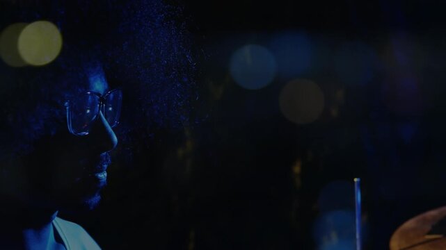 Animation on blurred night road traffic over hands of african american percussion player