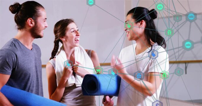 Trio carrying yoga mats greeting barre gesturing as network icons overlaying wall preparing session