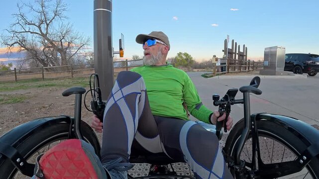 Senior cyclist is riding a full suspension recumbent on Poudre River Trail in northern Colorado and crossing a street at traffic lights