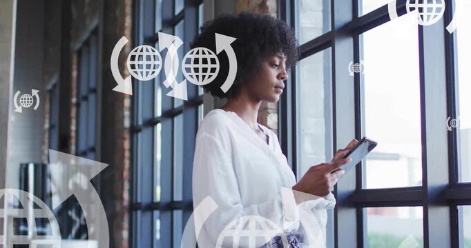 Animation of globe and arrow icons over african american woman using smartphone