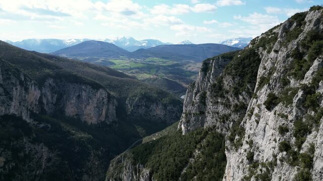 Aerial drone footage over Frasassi Gorge, Italy: rocky cliffs, green vegetation and dramatic natural landscape. Ideal for travel, nature and geological projects.