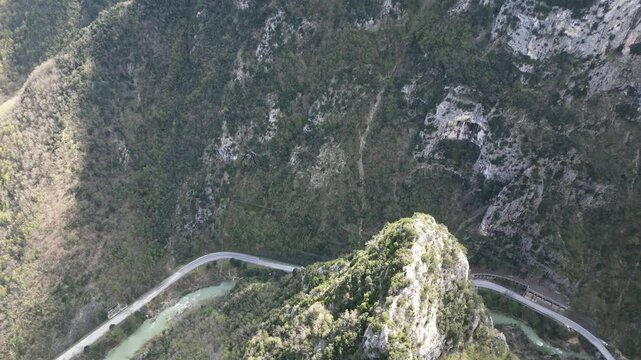 Aerial drone footage over Frasassi Gorge, Italy: rocky cliffs, green vegetation and dramatic natural landscape. Ideal for travel, nature and geological projects.