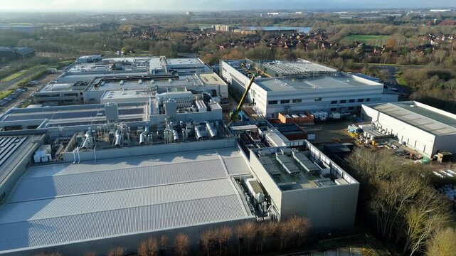 Aerial view of industrial factories and high-capacity fulfillment centers with integrated road transport networks.