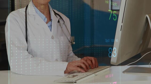 Clinician typing on keyboard at clinic desk, displaying ECG waveforms and monitoring patient vitals