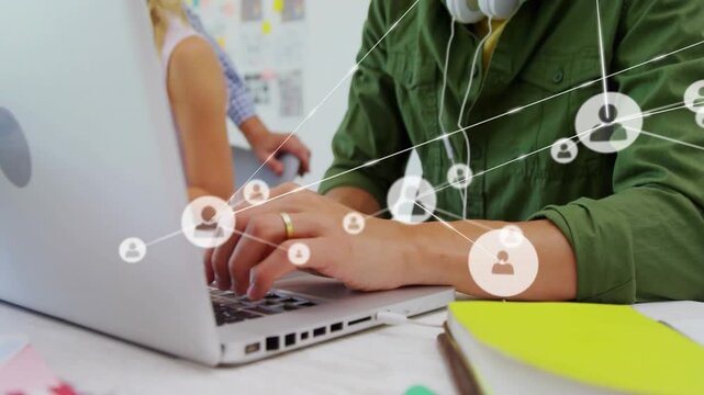Male typist typing on laptop initiating animated network nodes spreading, showing tech teamwork