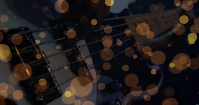Musician plucking bass strings while recording music, warm bokeh overlay drifting over pickups