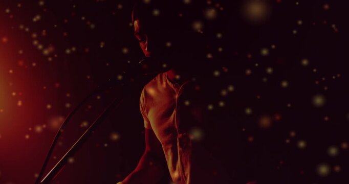 Musician playing keys, leaning to mic and singing for music session, particles crossing silhouette