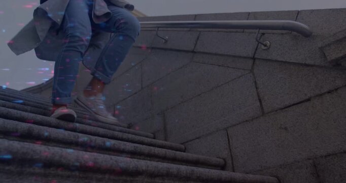 Man descending stone steps while checking phone causing tech overlays marking sneakers passing lens