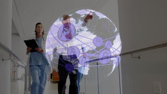 Medical team walking corridor while doctor pointing triggers rotating globe over tablet, for care
