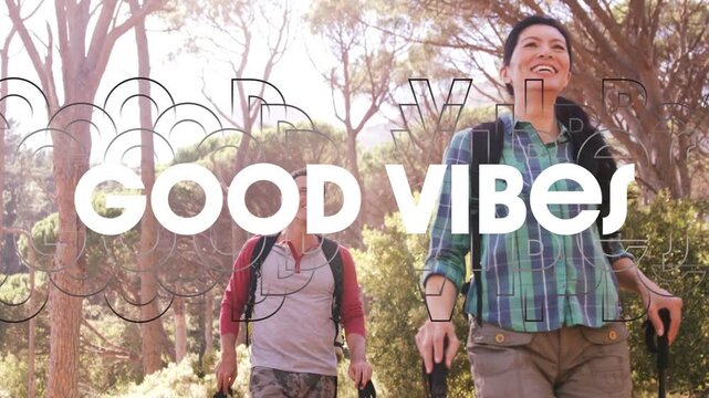 Vertical video: Couple hiking path walking making cam shifting and GOOD VIBES overlay travel poles