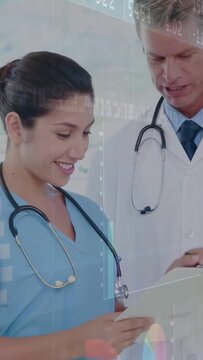 Vertical video: Nurse reading chart, doctor annotating for health review, overlaying data graphs