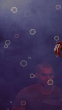 Vertical video: Camera panning revealing band on purple stage with bubbles, singer singing into mic