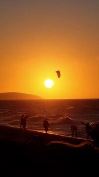 Dramatic Orange Sunset with People Silhouettes, Kite and Jangada on the Ocean. Jericoacoara, Ceara, Brazil